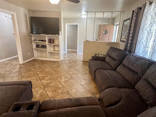 tiled living room with a ceiling fan and baseboards