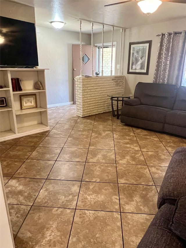 tiled living area featuring ceiling fan and baseboards