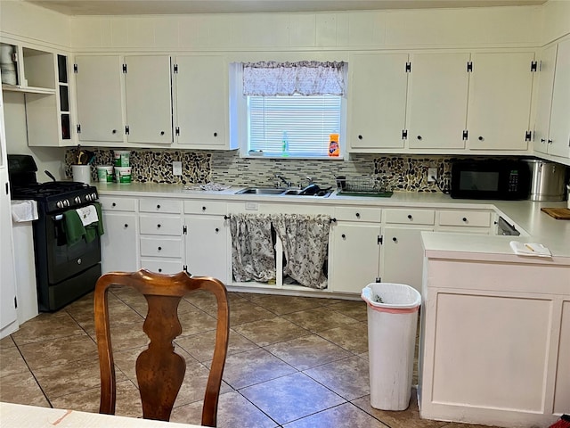 kitchen featuring tile patterned floors, a sink, light countertops, black appliances, and backsplash