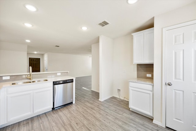 kitchen featuring a sink, visible vents, light wood-style floors, decorative backsplash, and dishwasher