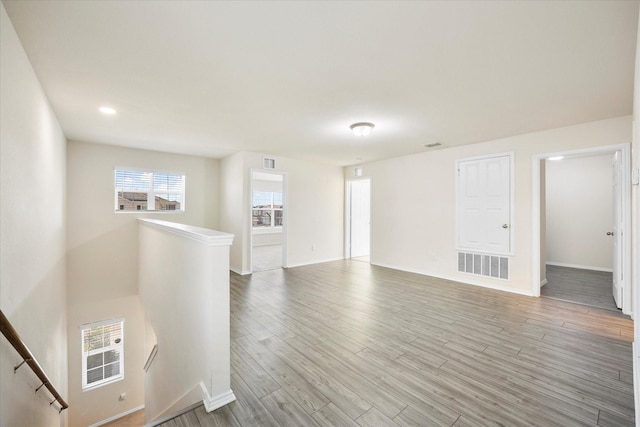 unfurnished room featuring light wood-type flooring, visible vents, and baseboards