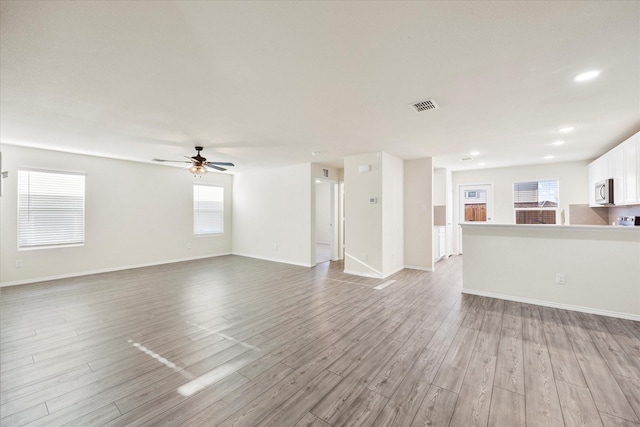 unfurnished living room featuring ceiling fan, recessed lighting, visible vents, baseboards, and light wood-type flooring