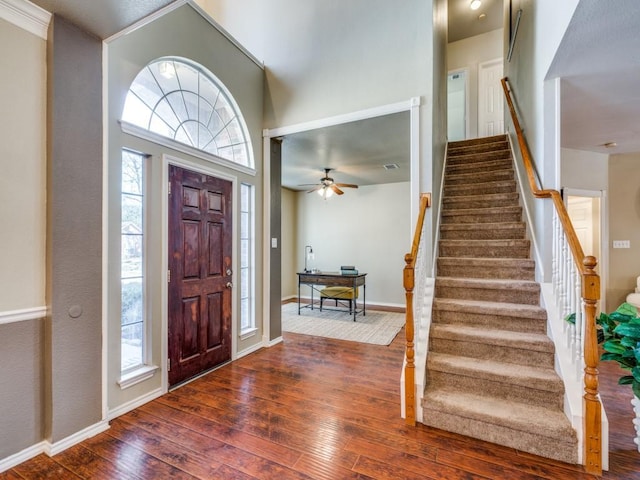 foyer entrance featuring hardwood / wood-style flooring, stairway, and baseboards