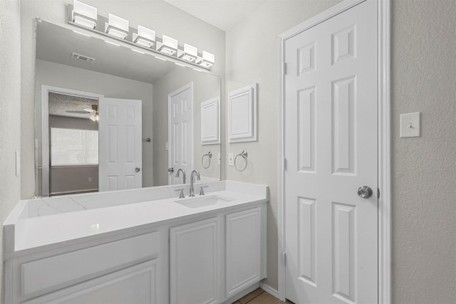 bathroom with tile patterned floors, visible vents, a ceiling fan, and vanity