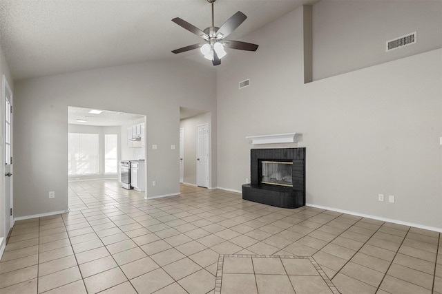 unfurnished living room featuring light tile patterned floors, lofted ceiling, visible vents, a ceiling fan, and a brick fireplace