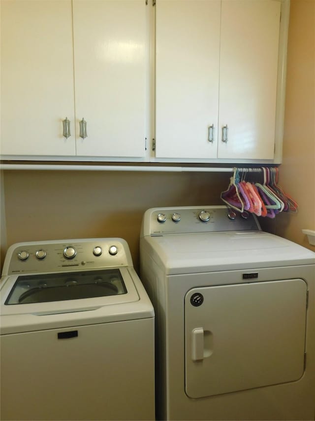 laundry room with washing machine and dryer and cabinet space