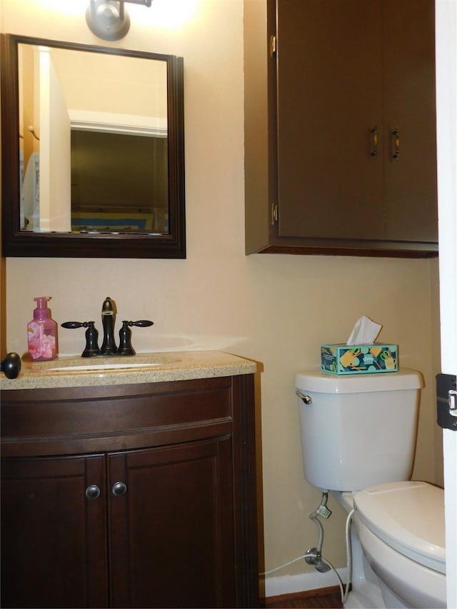 bathroom featuring vanity, toilet, and baseboards