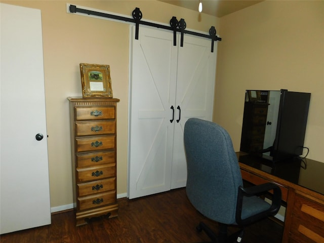 office featuring a barn door, baseboards, and dark wood-type flooring