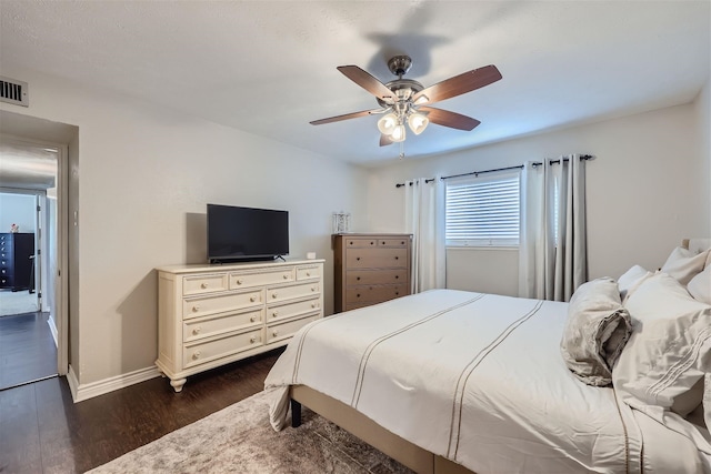 bedroom featuring dark wood finished floors, baseboards, and ceiling fan