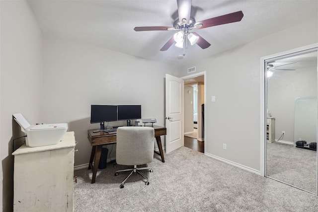 home office featuring a ceiling fan, carpet flooring, visible vents, and baseboards