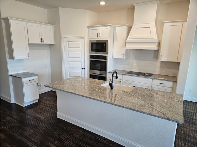 kitchen with white cabinets, custom range hood, a sink, and black electric cooktop