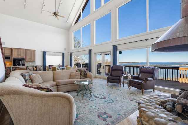 living area featuring high vaulted ceiling, ceiling fan, and wood finished floors