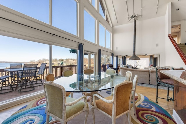 dining room with light wood finished floors and a towering ceiling