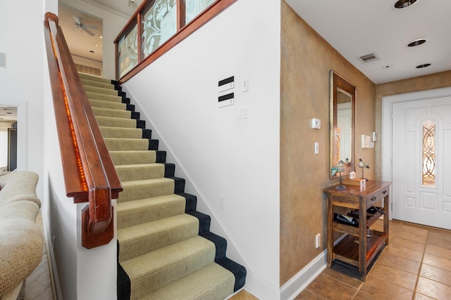 staircase with a ceiling fan, tile patterned floors, visible vents, and baseboards