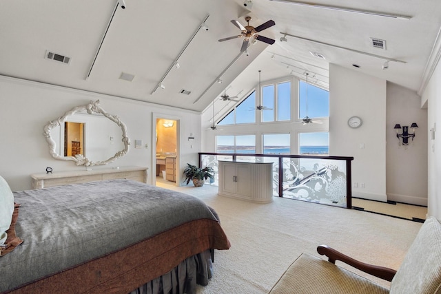 carpeted bedroom with high vaulted ceiling, baseboards, visible vents, and track lighting