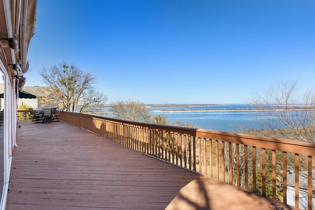 wooden terrace with outdoor dining space and a water view