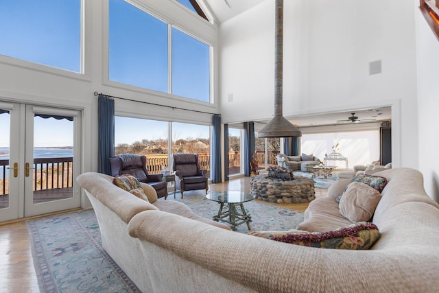 living area featuring lofted ceiling, visible vents, wood finished floors, and french doors