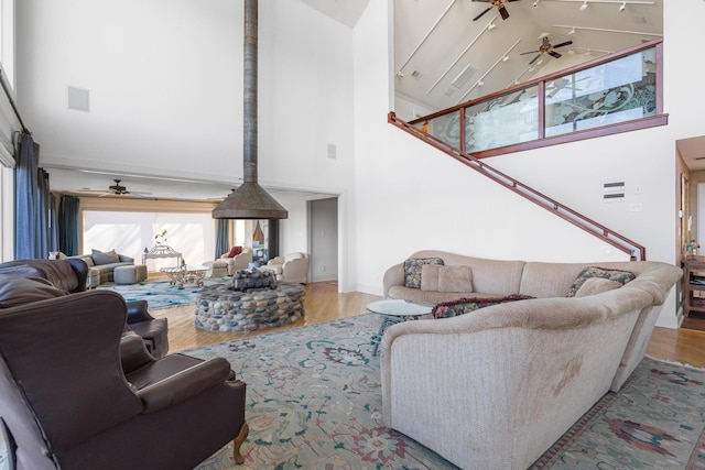 living area with ceiling fan, visible vents, high vaulted ceiling, and wood finished floors