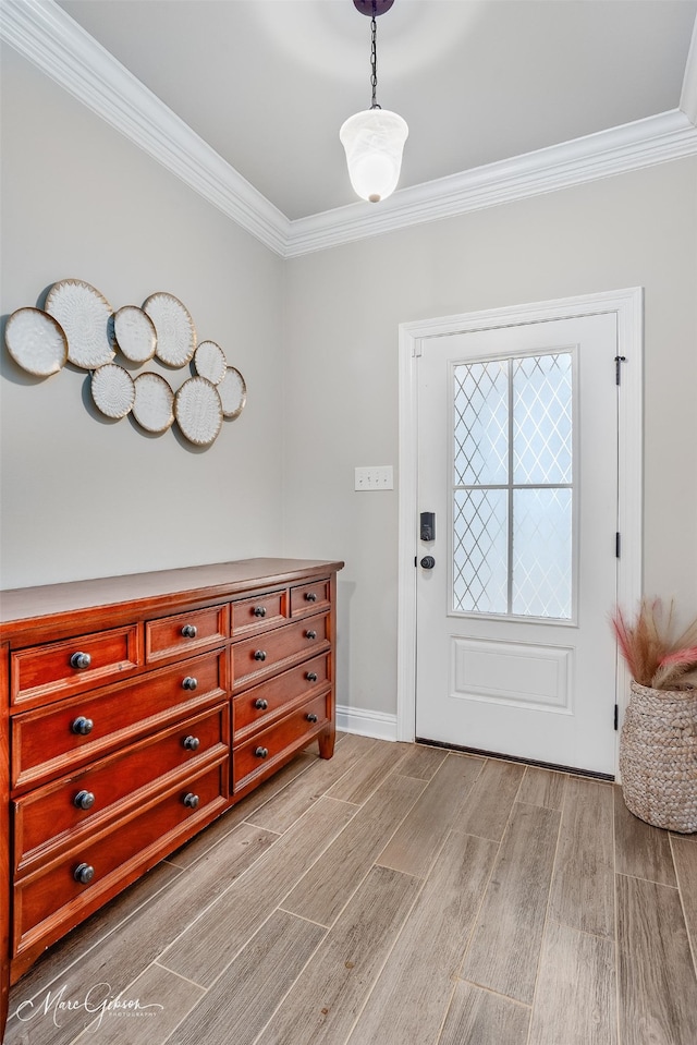 doorway featuring baseboards, light wood-style flooring, and crown molding