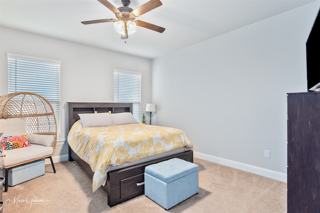 bedroom with ceiling fan, baseboards, and light colored carpet