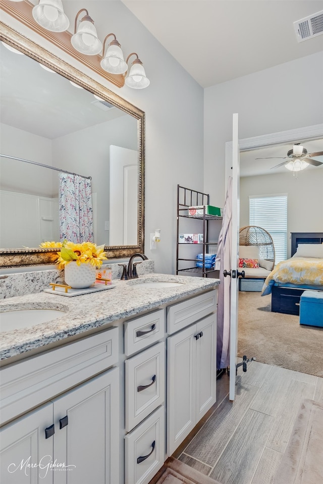 bathroom with double vanity, visible vents, a sink, and ensuite bathroom