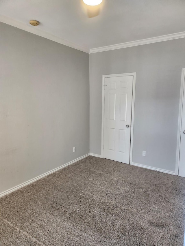 unfurnished room featuring ornamental molding, carpet, and baseboards