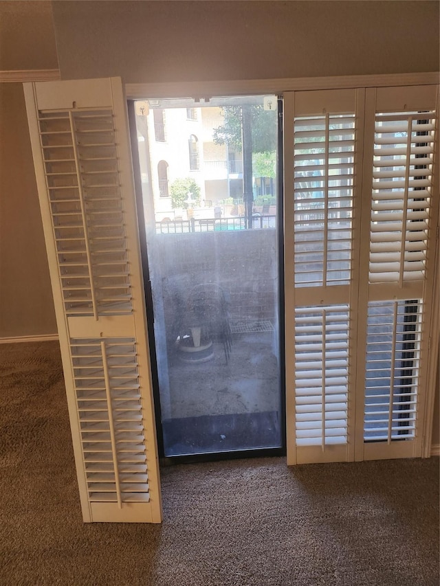 doorway to outside featuring carpet flooring