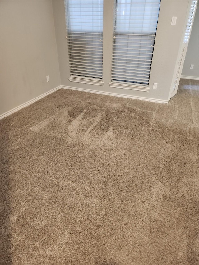 unfurnished room with baseboards and carpet flooring