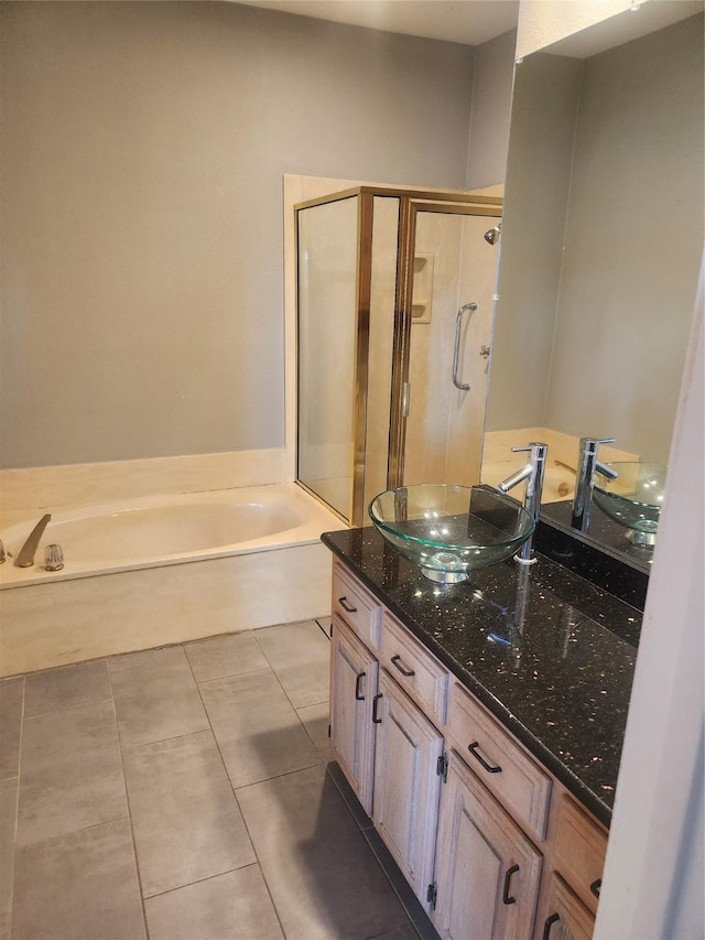 bathroom featuring a garden tub, vanity, a shower stall, and tile patterned floors