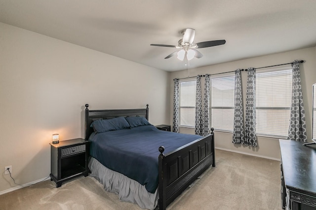 bedroom with a ceiling fan, light colored carpet, and baseboards