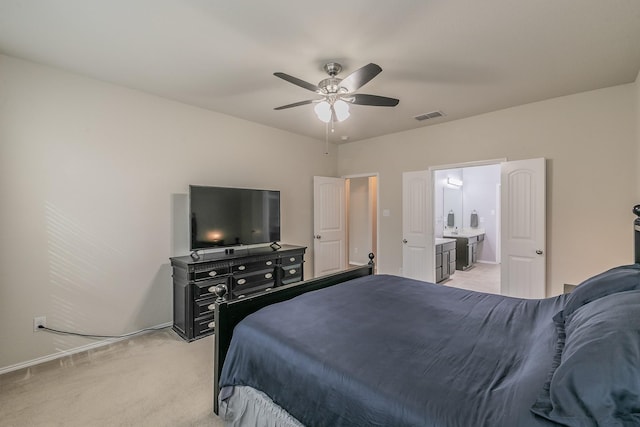 bedroom with visible vents, baseboards, light colored carpet, ceiling fan, and ensuite bathroom