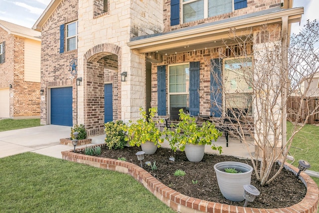 property entrance featuring an attached garage, fence, concrete driveway, and brick siding