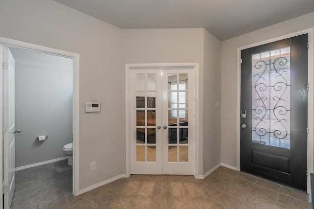 foyer entrance with french doors and baseboards