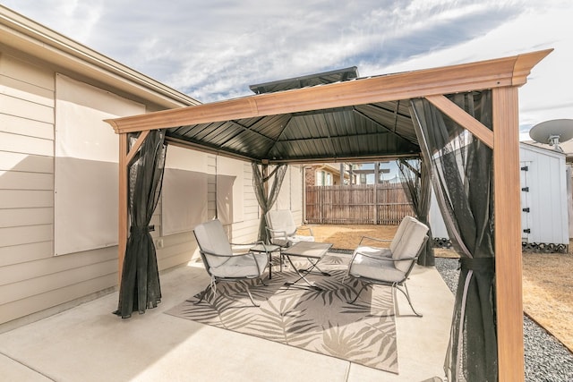 view of patio featuring a shed, fence, an outdoor structure, and a gazebo