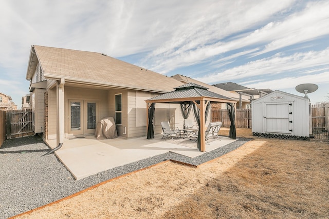 rear view of house with a patio area, a fenced backyard, a gazebo, and a storage shed