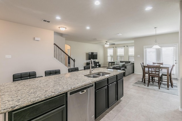 kitchen featuring visible vents, dishwasher, light stone countertops, a sink, and recessed lighting