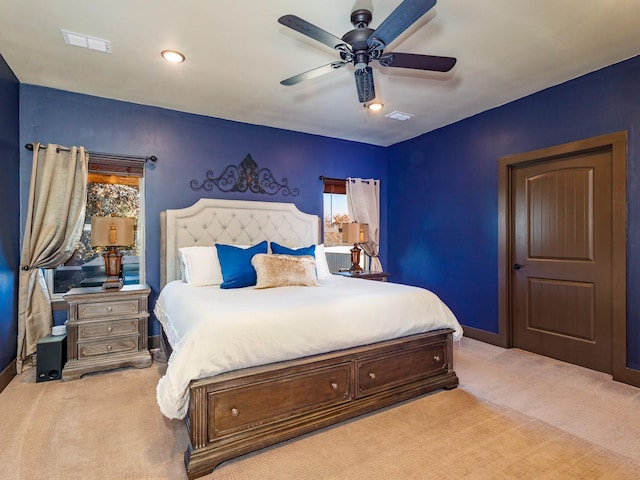 bedroom featuring light colored carpet, ceiling fan, visible vents, and baseboards