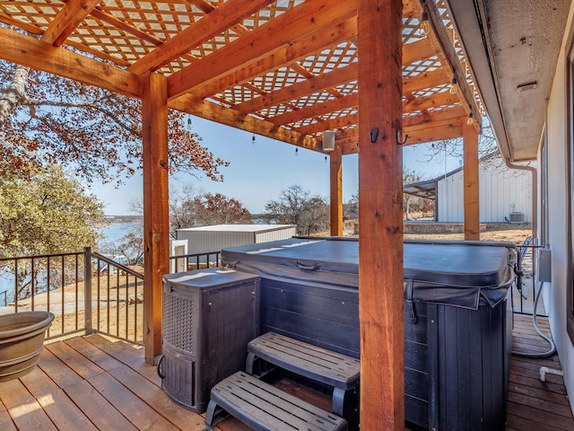 wooden deck featuring a hot tub and a pergola