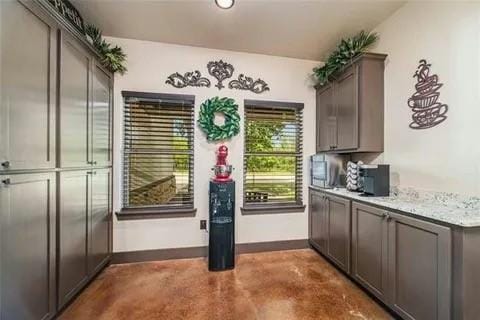 bar featuring concrete flooring and baseboards