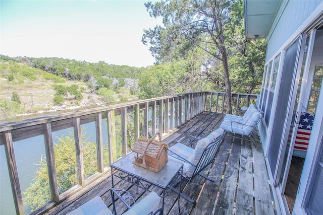 balcony with a wooded view and a water view