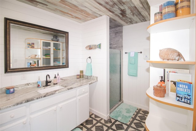 bathroom featuring tile patterned floors, vanity, a stall shower, and wooden ceiling