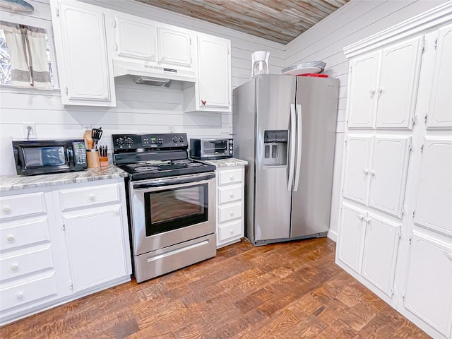 kitchen with under cabinet range hood, white cabinets, stainless steel appliances, and wood finished floors