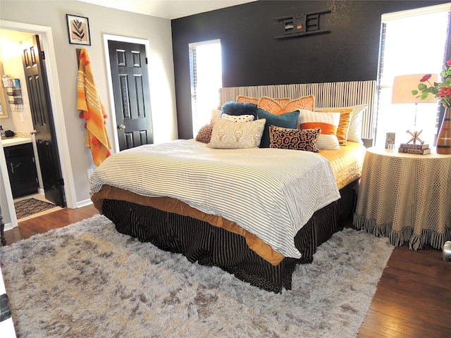 bedroom with baseboards and wood finished floors