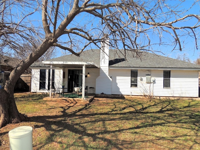 view of front facade featuring a shingled roof and a front lawn