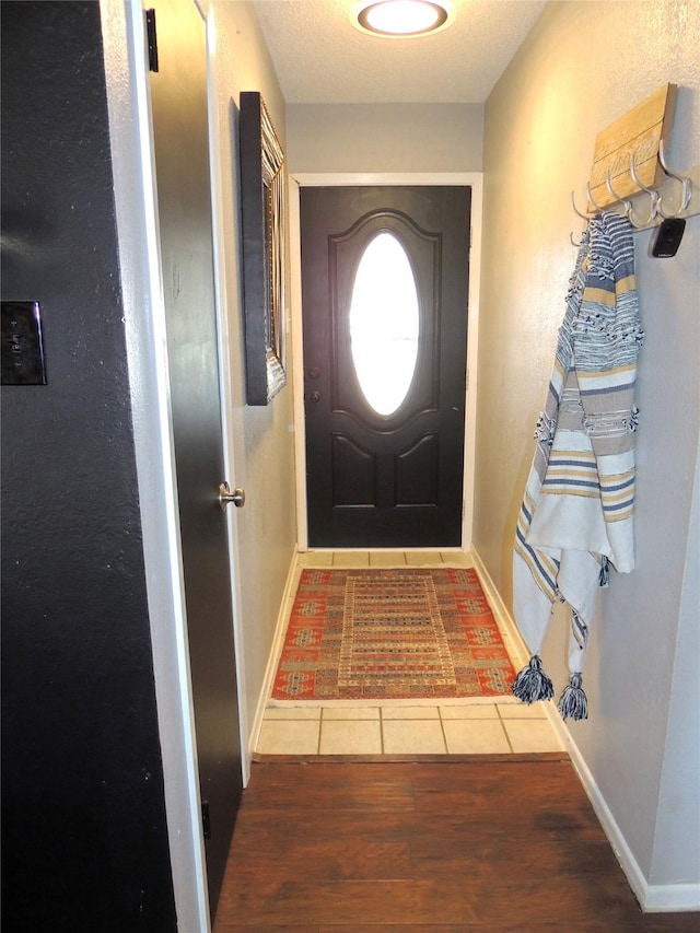 entryway with baseboards and wood finished floors