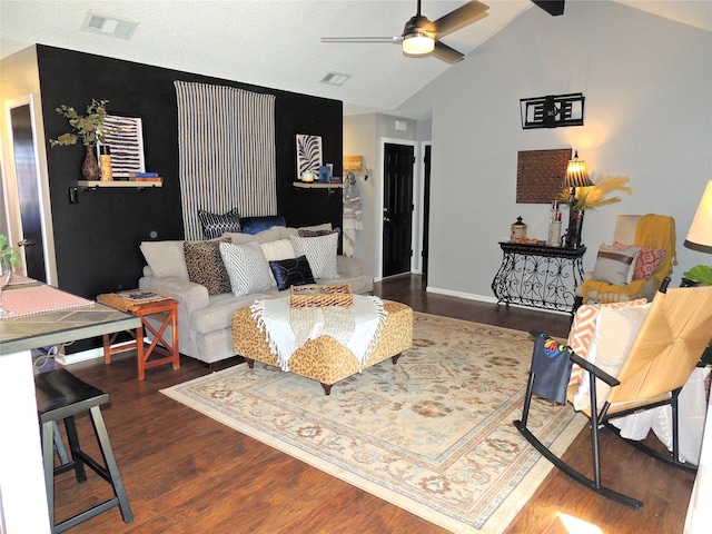 living area featuring wood finished floors, visible vents, baseboards, vaulted ceiling, and a ceiling fan