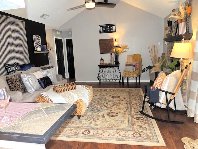 living area featuring visible vents, baseboards, lofted ceiling, ceiling fan, and wood finished floors