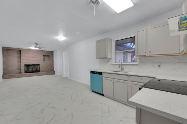 kitchen with marble finish floor, a ceiling fan, a brick fireplace, a sink, and dishwasher