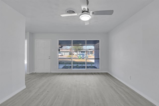 unfurnished room with a ceiling fan, baseboards, and wood finished floors