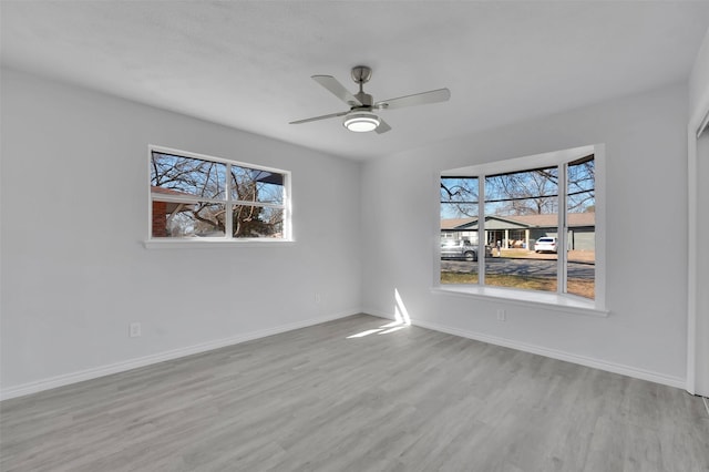 empty room featuring ceiling fan, wood finished floors, and baseboards